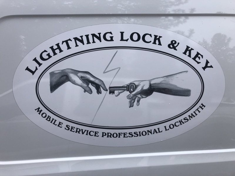 The Lightning Lock and Key logo on the company service van — two hands passing a key across a lightning bolt